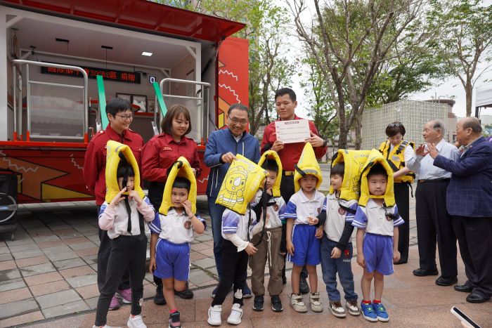 《圖說》侯友宜市長幫小朋友調整地震保護頭套。〈社會局提供〉
