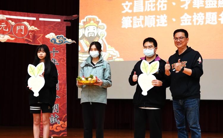 《圖說》鶯歌工商校長帶領學生，以蘿蔔、包子、粽子寓意「好彩頭、包中、包粽」展現校園陪伴。〈教育局提供〉