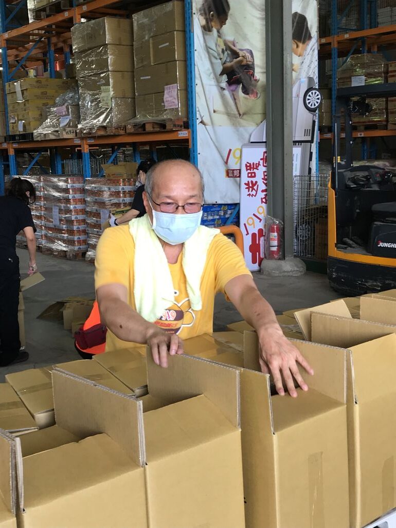 《圖說》邱大信到1919食物銀行八里倉庫幫忙整理食物箱 以寄送給弱勢案家。〈社會局提供〉